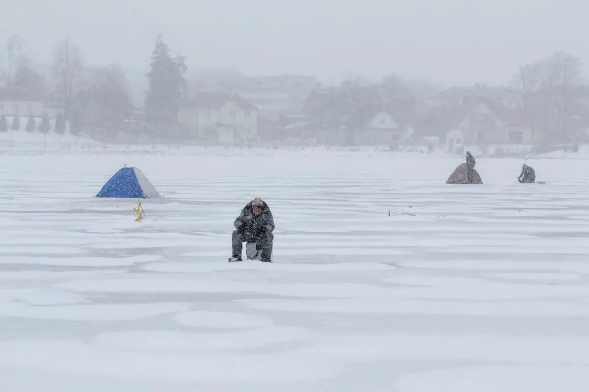 Man Ice Fishing on Lake